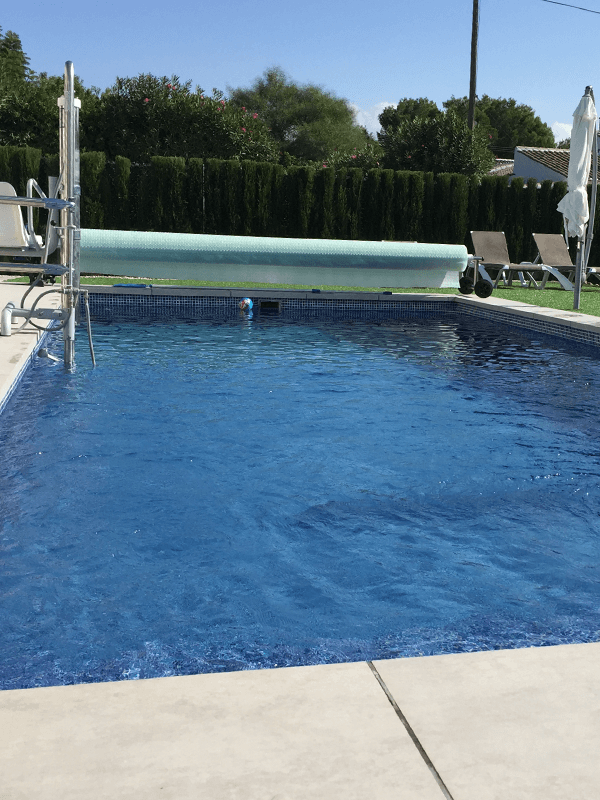 Villa Olivo's pool in the sun, with the hoist at the poolside